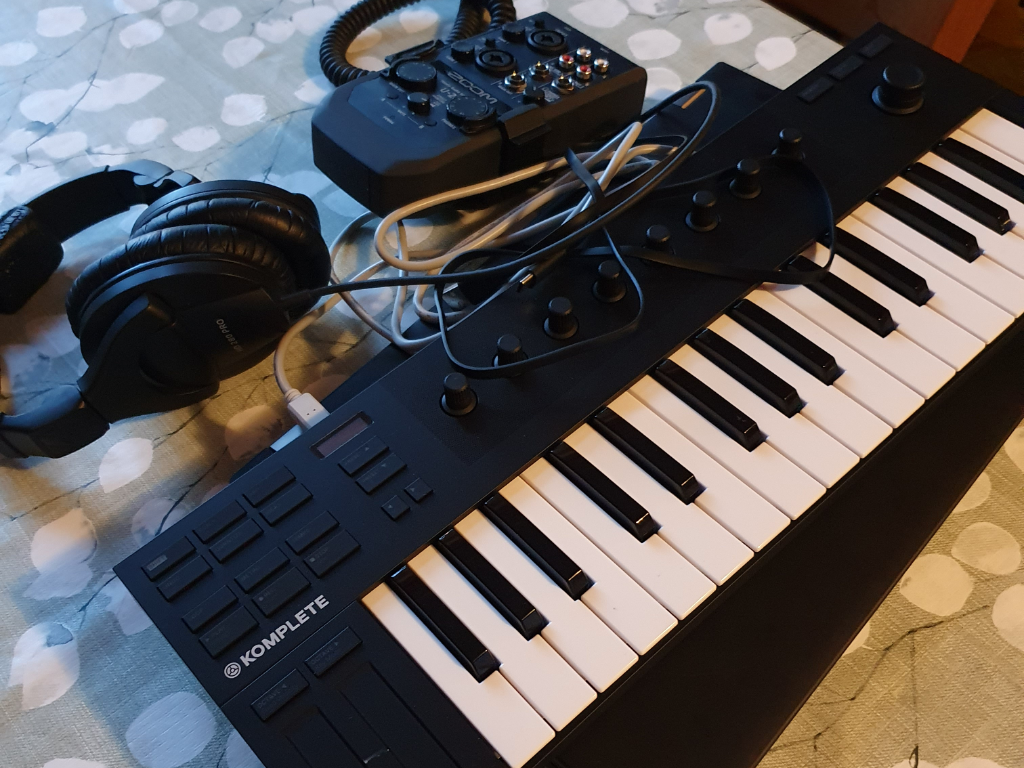 A laptop, a compact audio interface, a headset and a mini keyboard